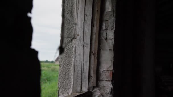 ぼやけた黒いロープのシルエットが古い家の窓の穴にかかって — ストック動画