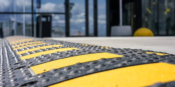 Svart och gul hastighet bula ligger på väg nära butiken — Stockfoto