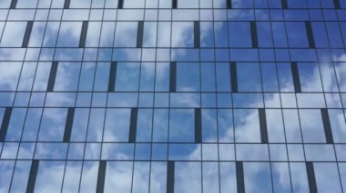 Cam dış görünüşlü ticari şehir binası bulutları yansıtıyor