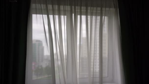 Cortinas brancas onduladas pelo vento leve no quarto escuro de manhã — Vídeo de Stock