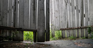 Kırık tahtaları olan büyük bina kapıları.