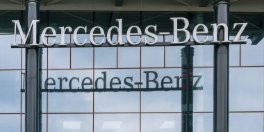 Gri metal Mercedes-Benz logosu hizmet veren siyah sütunlar üzerinde