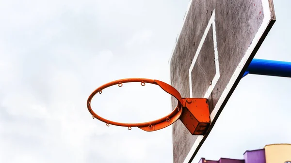 Basketkorg på svarta tavlan under molnig himmel låg vinkel — Stockfoto