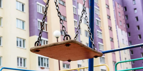 Винтажные деревянные качели на старых ржавых цепях на местной детской площадке — стоковое фото