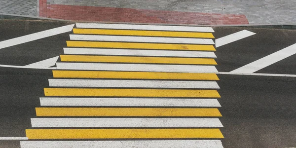 Passage piétonnier avec lignes blanches et jaunes sur route asphaltée — Photo