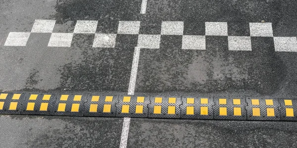 Verkeersdrempel van zwarte en gele kleuren op asfaltweg — Stockfoto