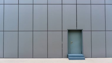 Gri merdivenli yerel ticari binanın küçük kapısı.