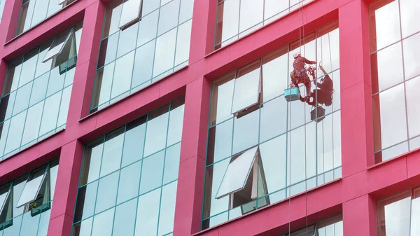professional washer cleans panoramic window of building