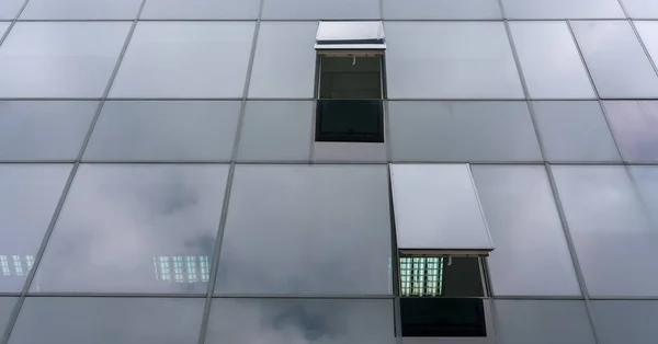 Corporate building panoramic glass wall reflecting clouds — Stock Photo, Image