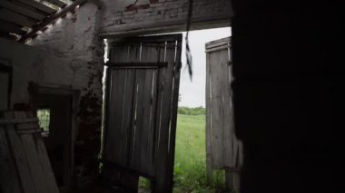 Karanlık, terk edilmiş ahşap bir kapı, çayıra karşı.