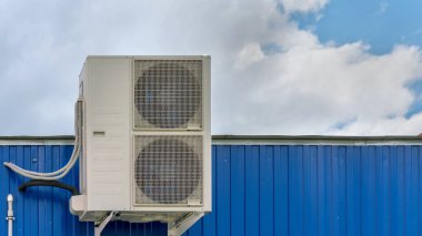 Yerel binanın mavi duvarında beyaz klima var.