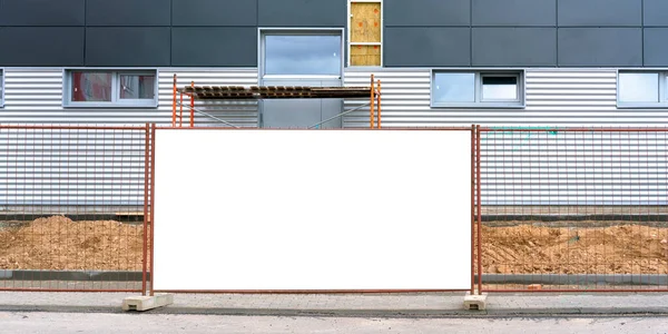 Binanın etrafını çitlerle çevreleyen büyük beyaz pankart