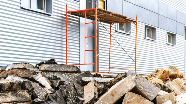 Escombros de construcción de piedra contra andamios en la pared del edificio —  Fotos de Stock