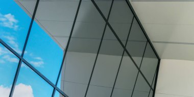 Yerel binanın büyük panoramik pencereleri mavi gökyüzünü yansıtır