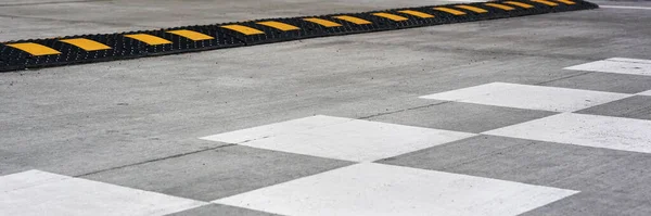 Bosse de vitesse noire et jaune près du marquage routier blanc — Photo