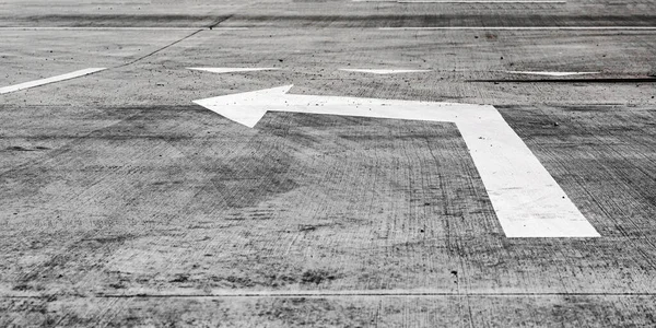 Flèche de marquage de couleur blanche située sur route asphaltée grise — Photo