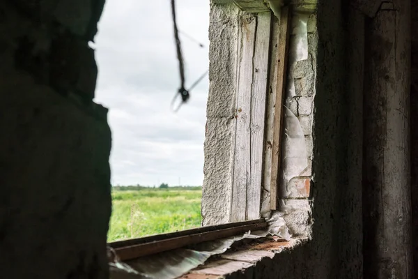 Verouderd dorpsgebouw met bakstenen muur en gebroken raam — Stockfoto