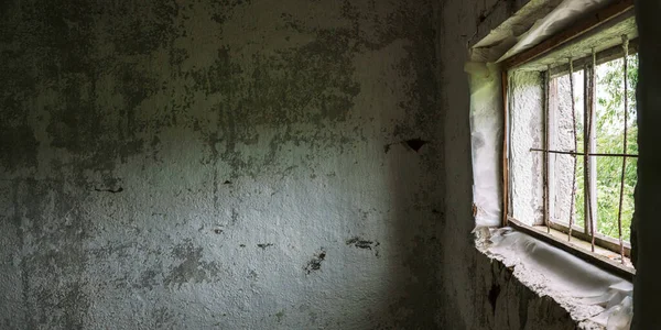 Bâtiment abandonné avec fenêtre en bois recouverte de grille — Photo