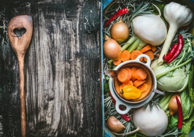Sağlıklı temiz gıda arka planı, çeşitli organik taze sebzeler, sandık içinde ve ahşap pişirme kaşığıyla kalbi koyu kırsal arka plan, üst manzara, çerçeve. Vejetaryen yeme konsepti