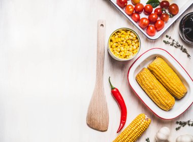 Beyaz kırsal arka planda tahta kaşıkla mısır pişirme hazırlığı, üst manzara, yazı için yer. Sağlıklı, temiz yiyecekler veya vejetaryen yemek ve yeme konsepti