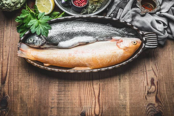 Twee Rauwe Forelvissen Bakvorm Met Ingrediënten Rustieke Houten Ondergrond Bovenaanzicht — Stockfoto