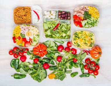 Beslenme çantalarındaki sağlıklı salataların çeşitliliği beyaz ahşap arka plan, üst görünüm