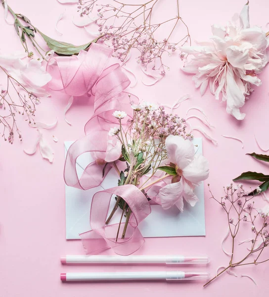 漂亮的粉红色花店的工作空间 美丽的花朵 彩带和铅笔在粉刷的背景上 顶视图 创意邀请和假日概念 — 图库照片