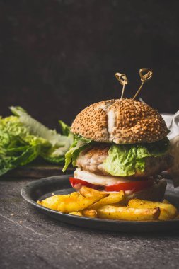 Tavuk, marul, mozzarella ve domatesli ev yapımı lezzetli hamburgerler.