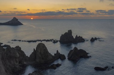 Salida del sol en el horizonte con el arrecife de las sirenas en primer trmino.