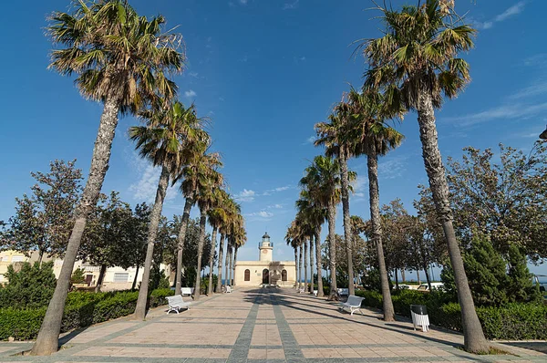 Paseo con palmeras frante al faro de Roquetas de Mar