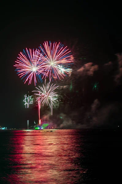 Festival de pirotecnia y su reflejo en el mar