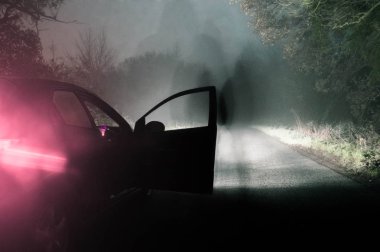 Hayalet siluet bekleyen bir araba üzerinde bir ürkütücü gece sisli, geceleri yol kışlar. İle soğuk, grenli Düzenle.