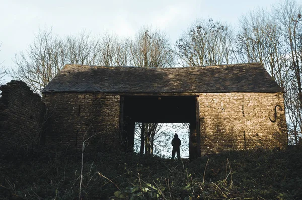 Sinister Silhouetted Hooded Figure Stands Ruined Old Barn Winters Day — Stock Photo, Image