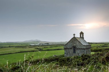 Pembrokeshire, Galler güneş ayarında arkasında ile izole St sigara'nın Şapel.