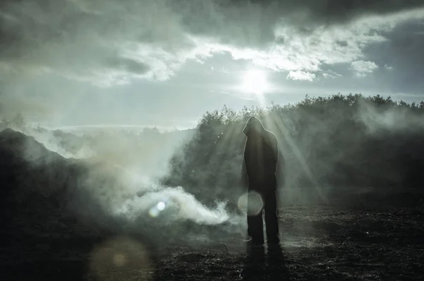 Lone Hooded Silhouetted Figure Standing Burnt Smoking Landscape High Contrast — Stock Photo, Image