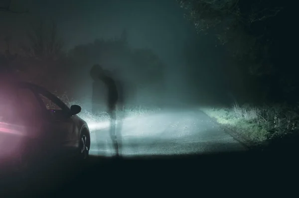 Uma Silhueta Fantasmagórica Encapuzado Figura Por Carro Noite Uma Estrada — Fotografia de Stock