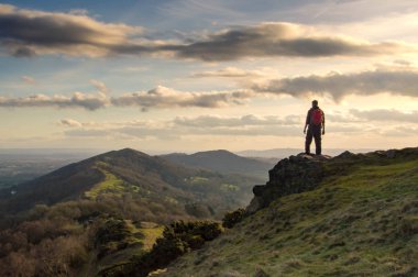 Yalnız fiyatı Malvern Hills, İngiltere'de sırtta bakan bir tepenin üstünde. Bir güneşli kış gün batımında.