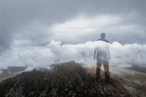 Eine Doppelbelichtung der Silhouette eines Mannes, der auf einen Berg blickt — Stockfoto