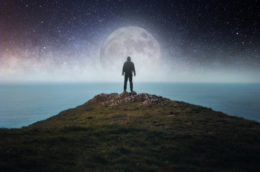 Bir tepede duran kapüşonlu bir figür kavramı denize bakıyor, ay, yıldızlar ve yukarıdaki evrenle..