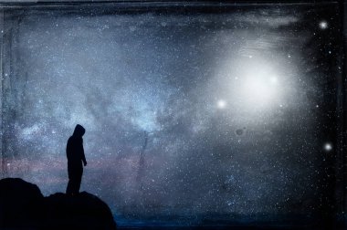 Yalnız kapüşonlu bir figür siluetli, bir tepenin üzerinde durup geceleri gökyüzünde yüzen Ufo'ların olduğu bir galaksiye bakıyor. Bir grunge ile, vintage edit.