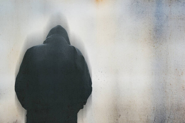 Сзади человек в капюшоне сутулился и грустил, представляя проблемы психического здоровья. С ухмылкой, размытой редакцией
.