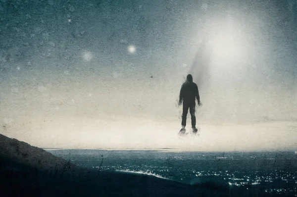 Samotna postać z kapturem unosząca się nad Wzgórzem, patrząc przez miasto w nocy, z UFOs pływających na niebie. Z grunge, Vintage Edit. — Zdjęcie stockowe