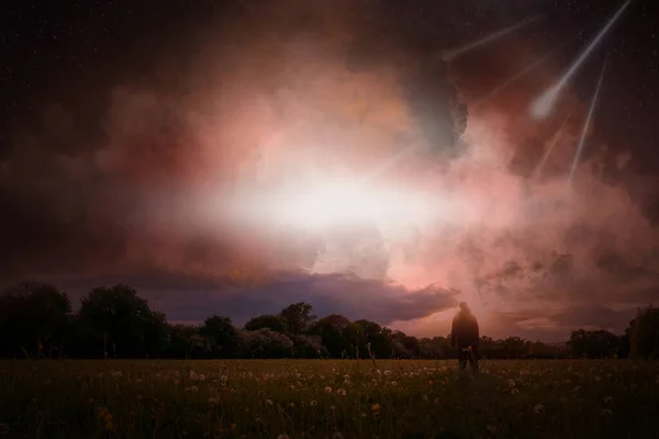 A post apocalypse scene showing a man standing, looking at asteroid falling from the sky.