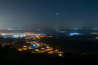 Geceleri sisle kaplı bir kasaba ve sokak ışıklarına bakıyorum. Gece gökyüzünde parlayan Venüs gezegeniyle