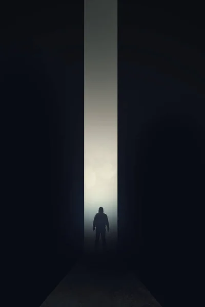 A lone hooded figure. Silhouetted in a dark corridor. With a glowing light behind.