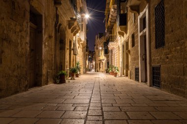 Birgu gece, uzun pozlama vurdu sokakta. düşük açılı. bulanık hareket insanlar. hiç kimse, gece huzurlu yollar. Malta dar sokakları. 