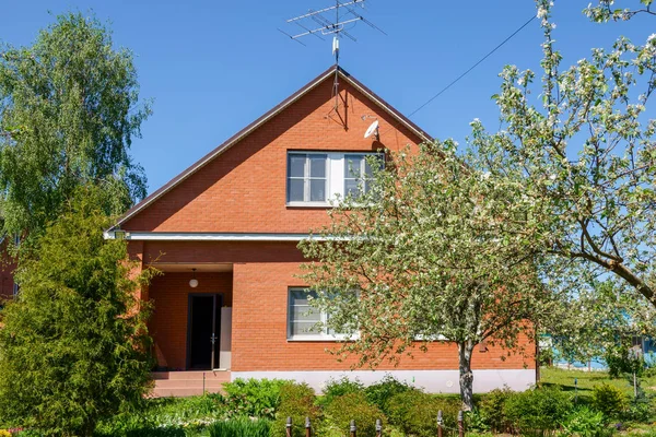 Red russian house with metal roof and metal fence — Stock Photo, Image