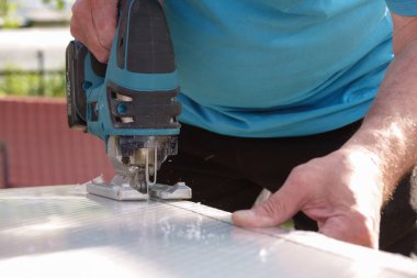 Cutting polycarbonate sheet by cutting machine jigsaw clipart