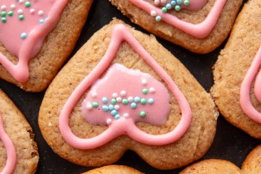 Eller, kalp şeklinde zencefilli kurabiye tutar.