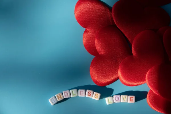 Word endless love made of round plastic blocks on the table blue color.